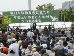 法政大学教授で立憲デモクラシーの会共同代表の山口二郎さんが登壇、「この夏の参議院選挙で与党の議席を減らすことで、流れを押し返すことができる」とアピール。辺野古基金共同代表の菅原文子さん、101歳のジャーナリストむのたけじさんらも力強くメッセージを述べた。5月3日、有明防災公園（江東区）