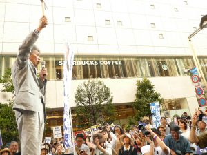 「非核都市宣言　憲法をまもり　平和を」と書かれたプラカードを掲げ、語りかける鳥越俊太郎都知事候補。7月24日